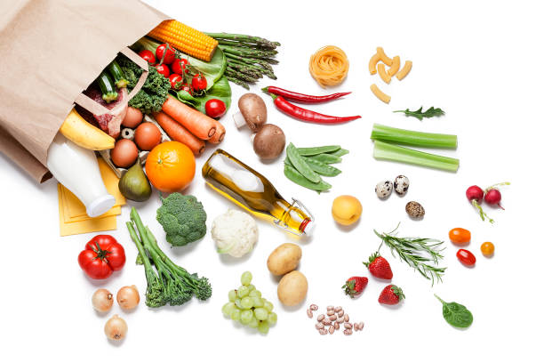 paper bag full of different food on white background - food stock pictures, royalty-free photos & images