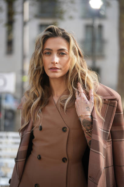 Paris Jackson wears a brown oversized checkered blazer jacket, a brown leather double breasted short coat worn as a mini dress, before Stella...
