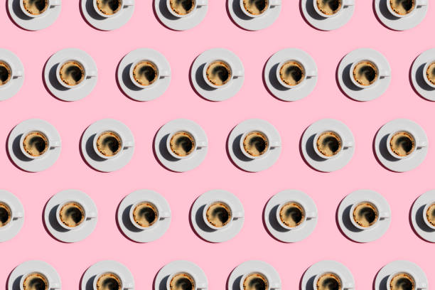pattern made of cup of fresh coffee on pastel pink color background. - coffee stockfoto's en -beelden