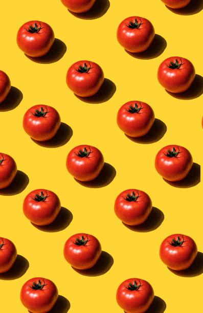pattern of sliced tomatoes on yellow background - food stock pictures, royalty-free photos & images