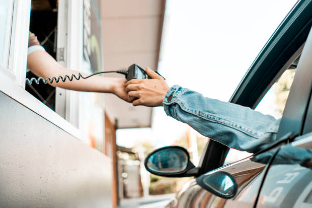 paying at drive through window - junk food stock pictures, royalty-free photos & images