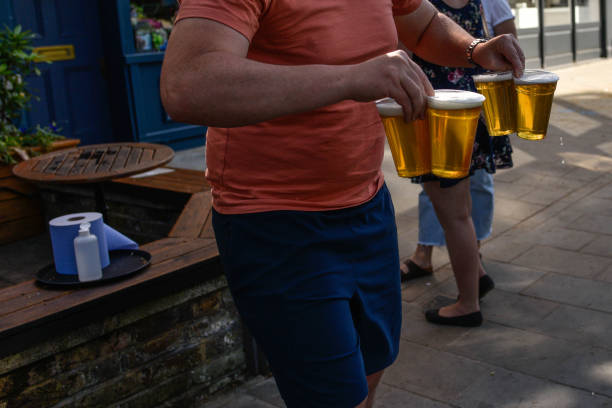 People are seen buying takeaway pints at a pub on Wandsworth Common on May 28 2020 in London, England. The prime minister announced the general...