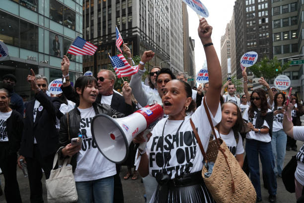 People cheer as they march in the "Fashion For Our Future" rally to raise awareness about the importance of voting in the upcoming election, during...