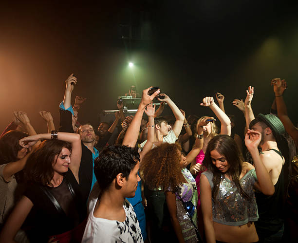 people dancing in crowded night club - concert stock pictures, royalty-free photos & images