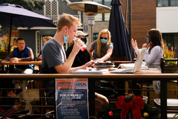 People eat take-out food outdoors at a "public parklet" due to Covid-19 restrictions on restaurant outdoor dining in Manhattan Beach, California,...