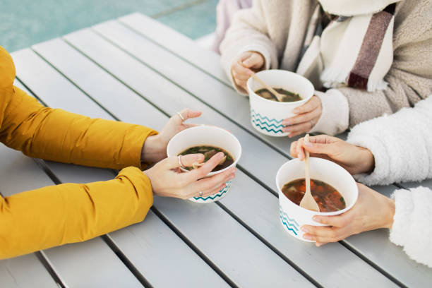 people eating hot soup in cold weather. street food concept. - junk food stock pictures, royalty-free photos & images