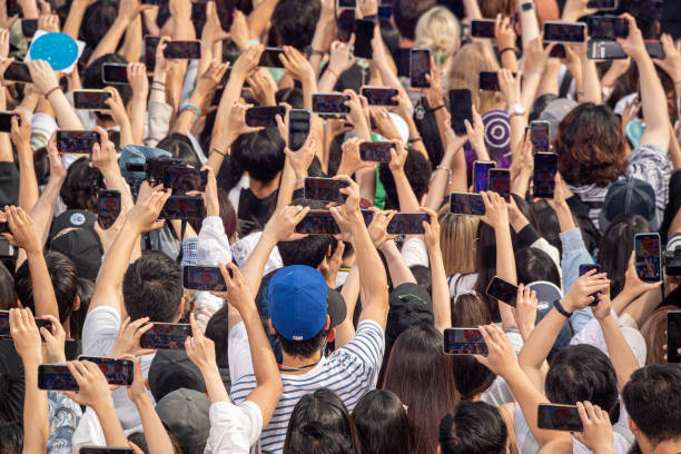 People hold up their phones while Aespa performs on ABC's "Good Morning America" at SummerStage at Rumsey Playfield, Central Park on July 08, 2022 in...