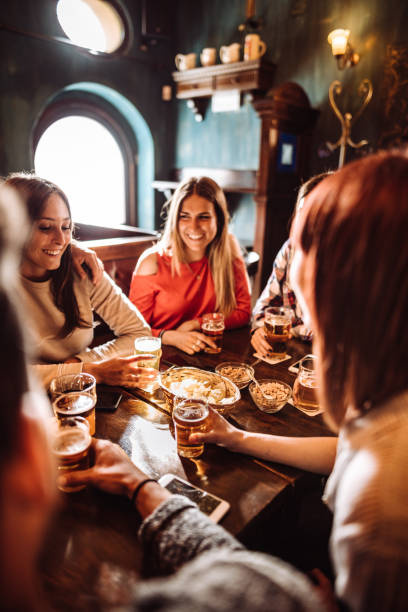 people talking indoors in a pub with the beers - food stock pictures, royalty-free photos & images