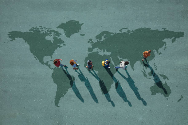 people walking in line across world map, painted on asphalt, front person walking left - travel stock pictures, royalty-free photos & images