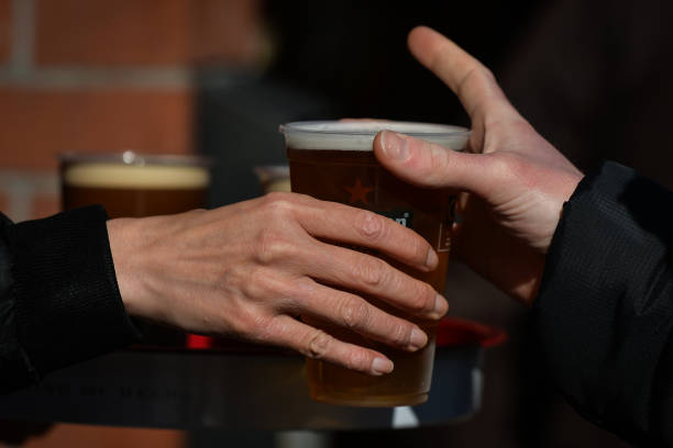 Person collecting a pint of lager beer in a plastic cup from the pub in Dublin's city center. On Thursday, 13 May 2021, in Dublin, Ireland.