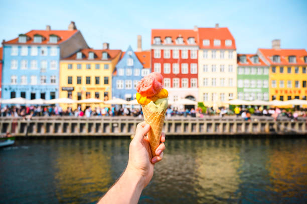 personal perspective of tourist holding an ice cream in front of nyhavn canal, copenhagen - food stock pictures, royalty-free photos & images