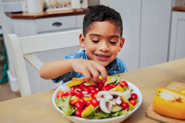 photo d’un petit garçon mangeant des légumes - food photos et images de collection