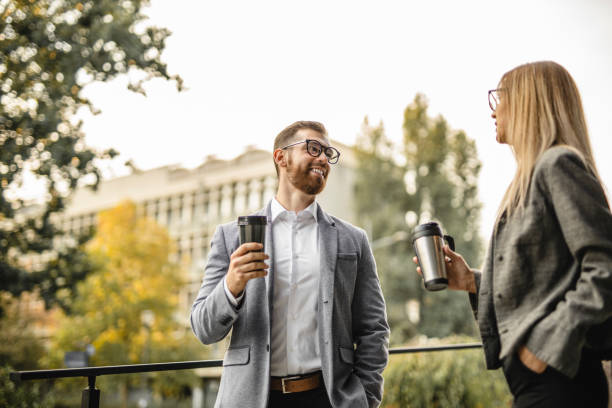 photo of two colleagues having a meeting and drinking coffee outdoors - junk food stock pictures, royalty-free photos & images