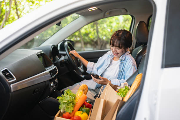 picking up her takeaway lunch in a drive through - junk food stock pictures, royalty-free photos & images