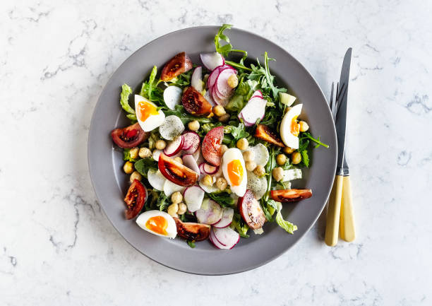 plate of fresh salad with boiled eggs on white background - food stock pictures, royalty-free photos & images