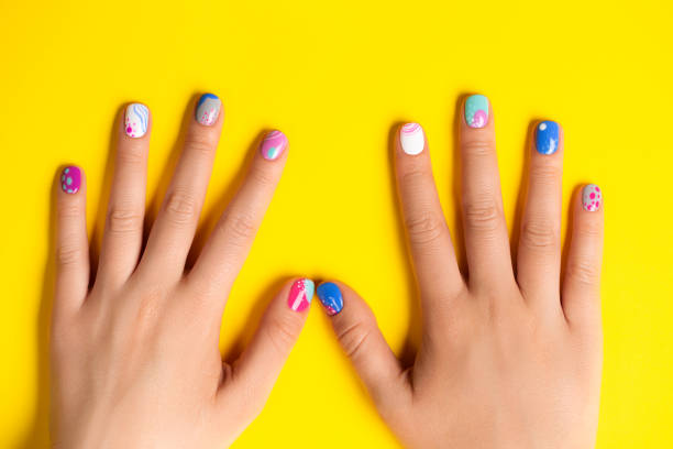 playful abstract art summer manicure in blue and purple colors on bright yellow background - nails art stock pictures, royalty-free photos & images