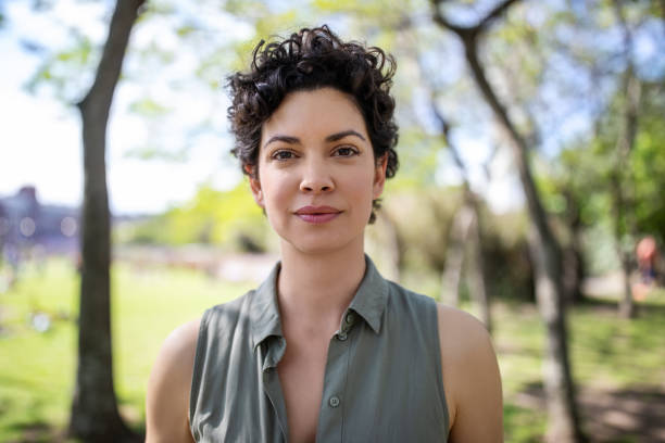 portrait of a confident young woman at the park - hairstyle stock pictures, royalty-free photos & images