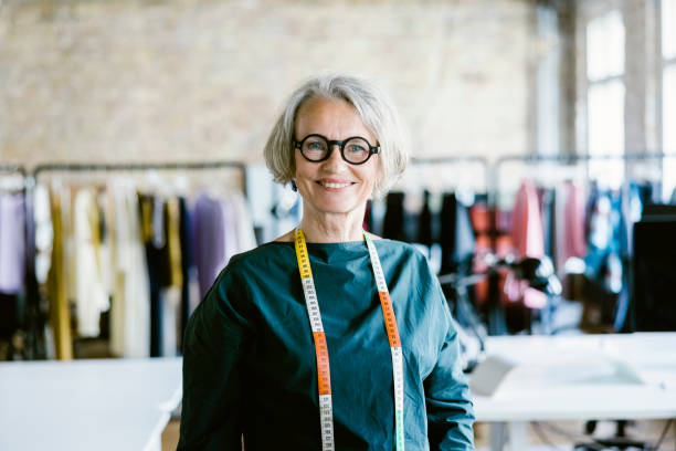 portrait of a happy senior woman fashion designer at her studio - fashion stock pictures, royalty-free photos & images