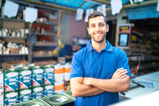 portrait of a young sales man standing in a paint store - home decoration stock pictures, royalty-free photos & images