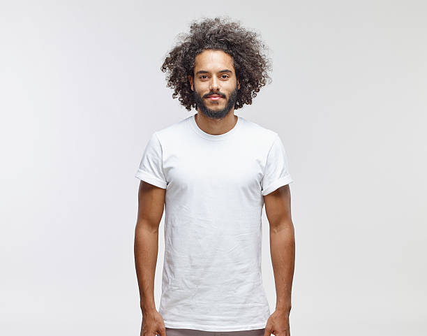 portrait of bearded young man with curly brown hair wearing white t-shirt - hairstyle photos et images de collection