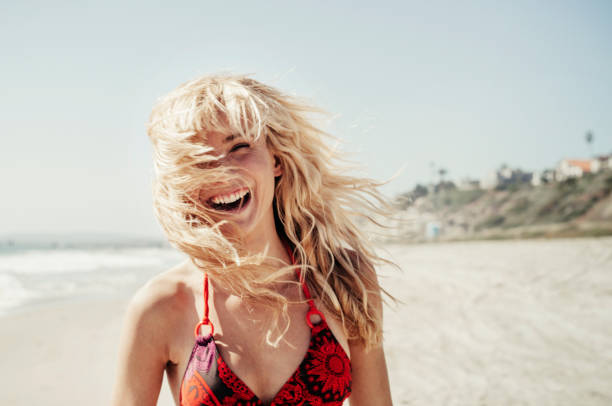 portrait of cheerful woman on beach - hairstyle stock pictures, royalty-free photos & images