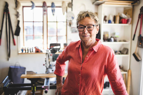 portrait of confident senior woman standing in workshop - home decoration stockfoto's en -beelden