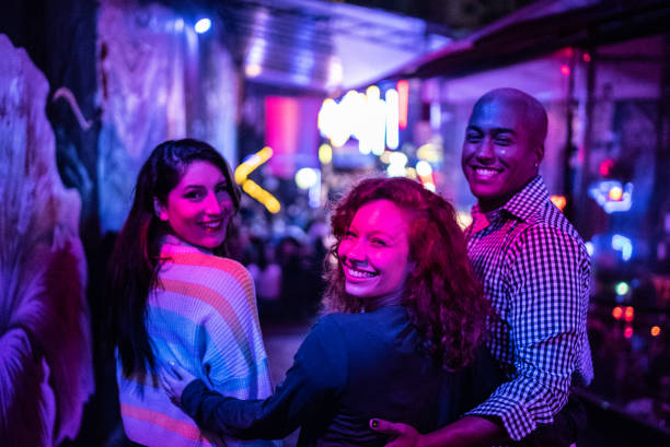 portrait of friends embracing at nightlife - including a transgender person - concert stock pictures, royalty-free photos & images