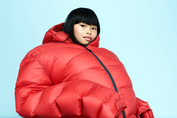 portrait of girl wearing huge coat - fashion stock pictures, royalty-free photos & images