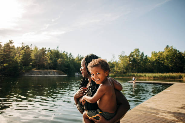 portrait of happy boy in mother arms during vacation - travel stock pictures, royalty-free photos & images
