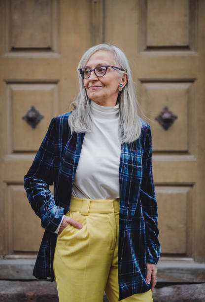 portrait of senior woman standing outdoors in town. - fashion stock-fotos und bilder