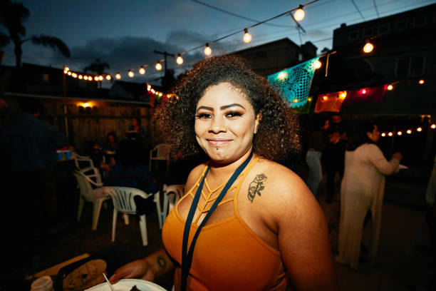 portrait of smiling woman in backyard during party with friends on summer evening - garden decoration stock pictures, royalty-free photos & images