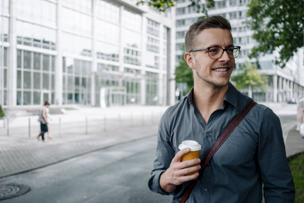 portrait of smiling young businessman with coffee to go - junk food stock pictures, royalty-free photos & images