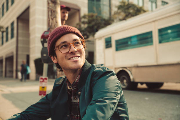 portrait of stylish young man sitting on sidewalk - fashion stock pictures, royalty-free photos & images