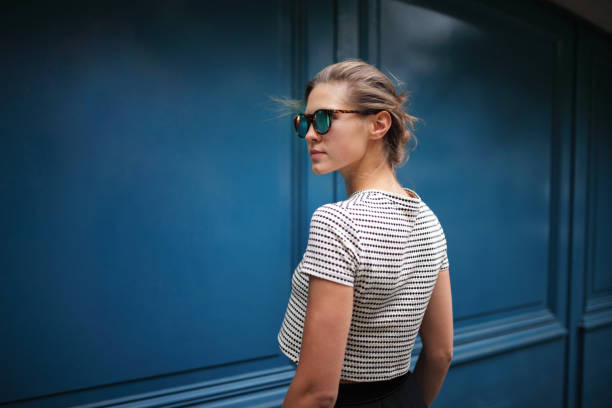 portrait of woman against blue wall - fashion stock pictures, royalty-free photos & images