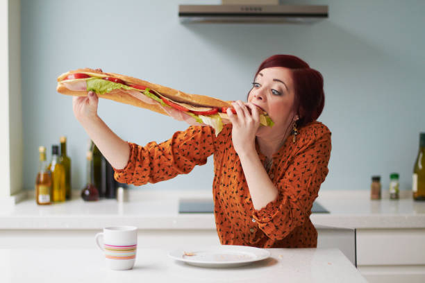 portrait of woman eating giant baguette - food stock pictures, royalty-free photos & images