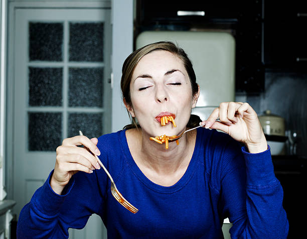 portrait of woman eating spaghetti - food stock pictures, royalty-free photos & images