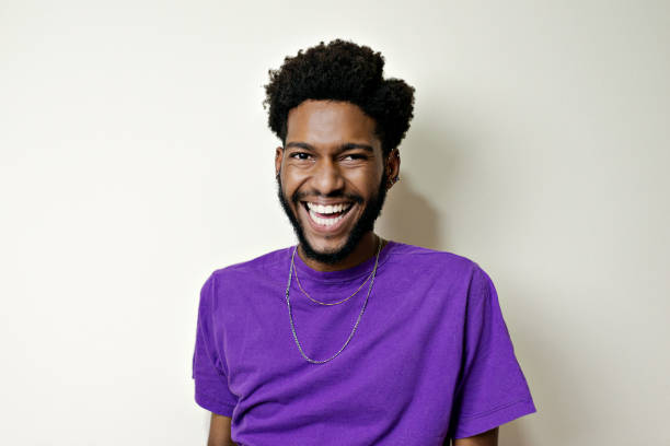 portrait of young bearded man smiling looking at camera. - hairstyle stock pictures, royalty-free photos & images
