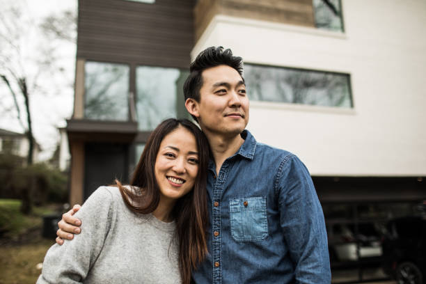 portrait of young couple in front of new home - home decoration stock pictures, royalty-free photos & images