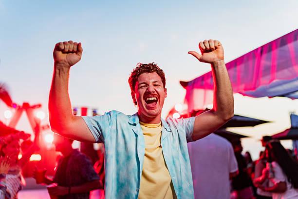 portrait of young man dancing on party outdoors - concert stock pictures, royalty-free photos & images