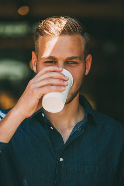 portrait of young man with coffee to go - junk food stock pictures, royalty-free photos & images