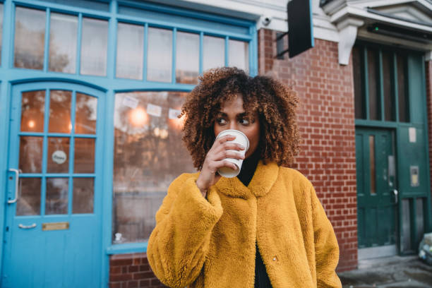 portret van een jonge volwassen mooie vrouw die koffie drinkt - coffee stockfoto's en -beelden