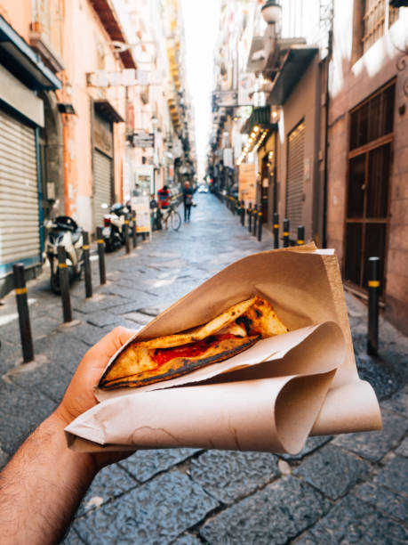 pov view of a man eating a typical "pizza a portafoglio" in naples, italy - food stock pictures, royalty-free photos & images