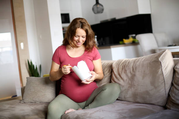pregnant woman eating chinese take away - junk food stock pictures, royalty-free photos & images