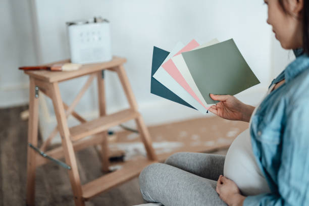 pregnant woman renovating nursery room for her newborn baby - home decoration stock pictures, royalty-free photos & images