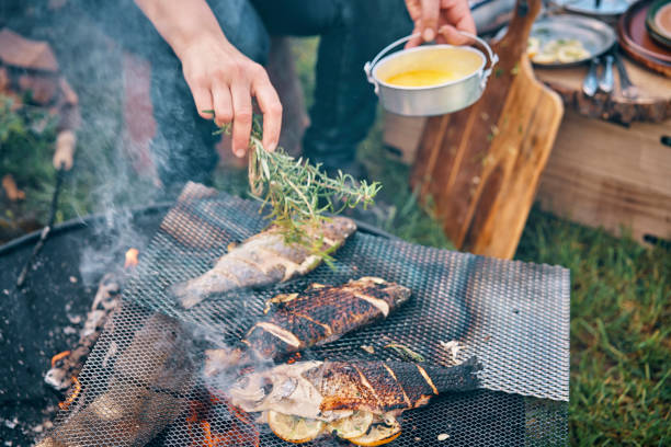 preparing fish for cooking over open campfire - food stock pictures, royalty-free photos & images