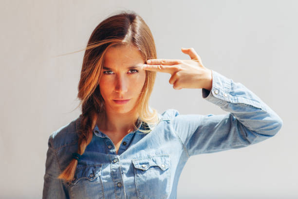 pretty woman pointing her finger to her head - hairstyle stockfoto's en -beelden