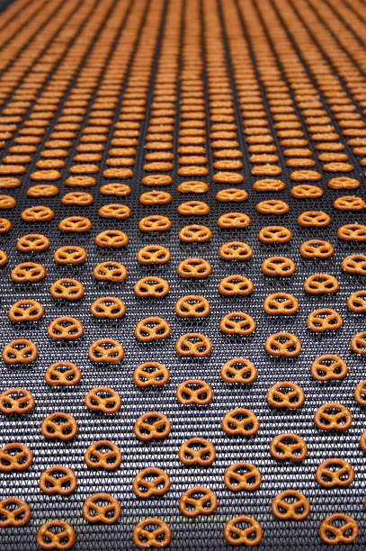 pretzels on conveyor belt in factory - food stock pictures, royalty-free photos & images