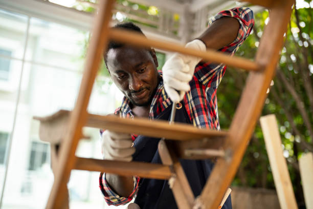 professional carpenter assembling wooden adirondack chair with screwdriver. manual work - home decoration stock pictures, royalty-free photos & images
