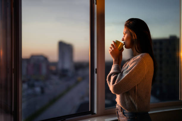 profielmening van mooie vrouw die koffie door het venster drinkt. - coffee stockfoto's en -beelden