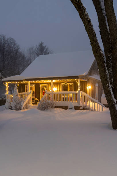 quaint snowy house at night decorated for christmas. fresh snow on the ground. - garden decoration stock pictures, royalty-free photos & images
